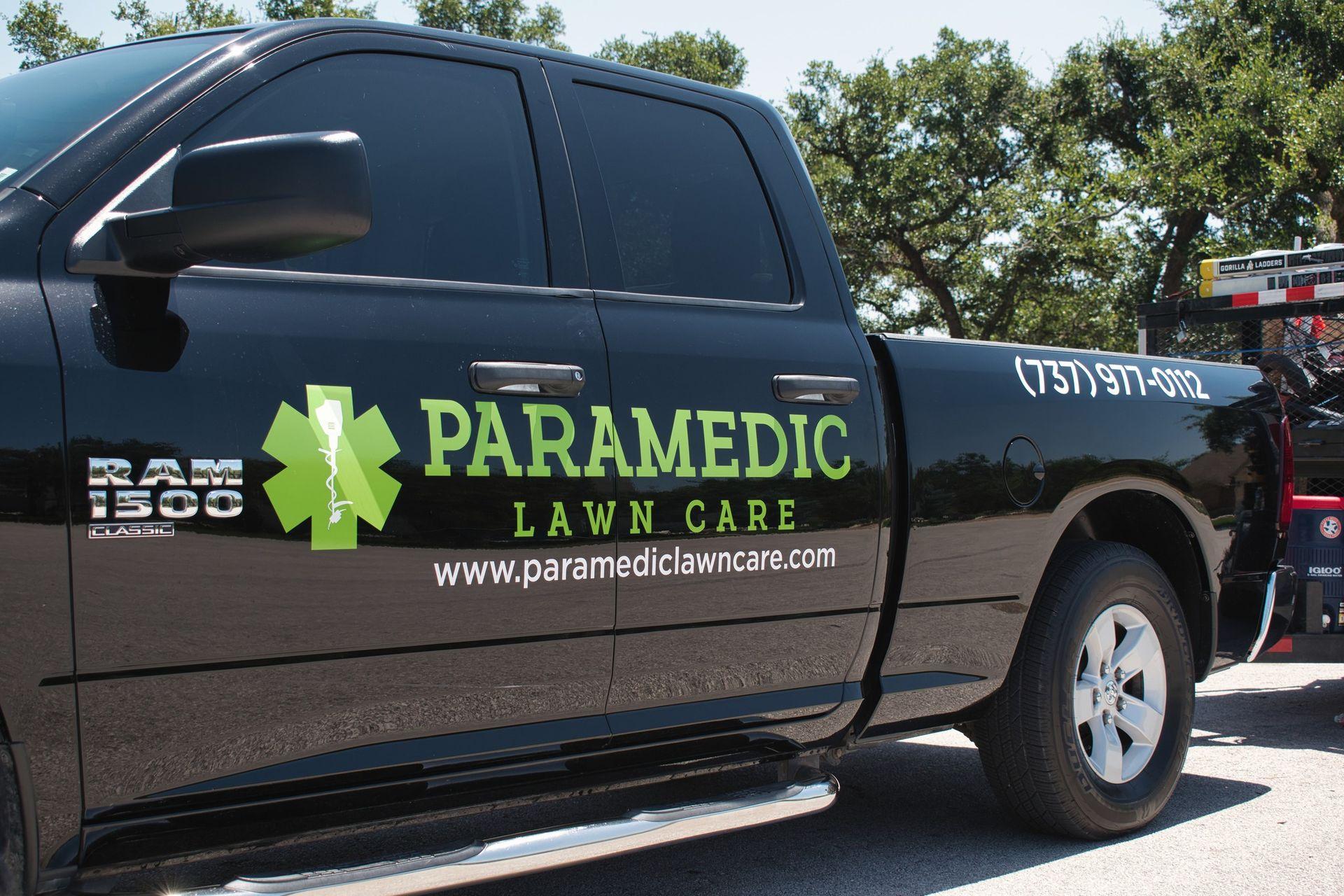 Black pickup truck with "Paramedic Lawn Care" logo, phone number, and website