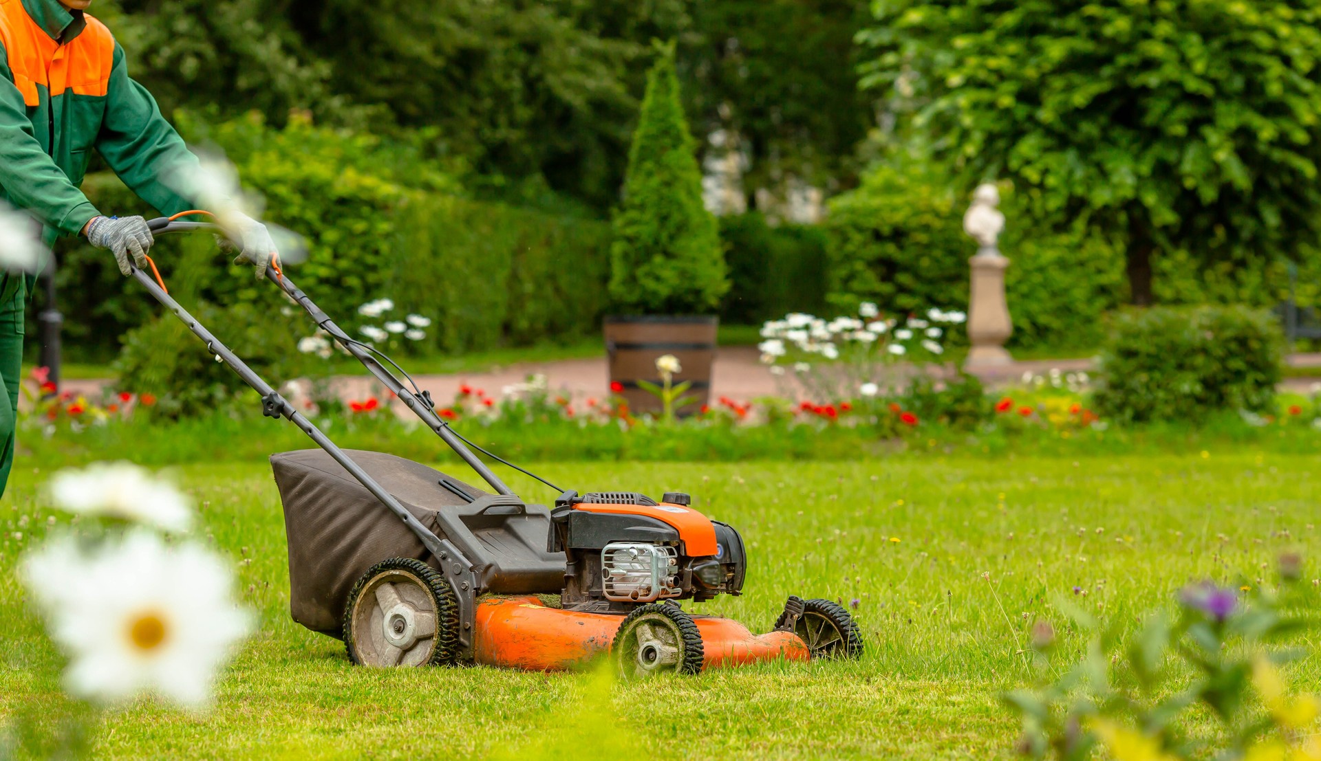 Banner. A human lawn mower cuts the grass in the backyard. Agricultural machinery for the care of the garden.